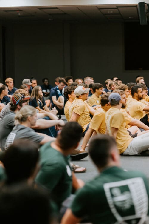 group of people sitting on the floor at a conference